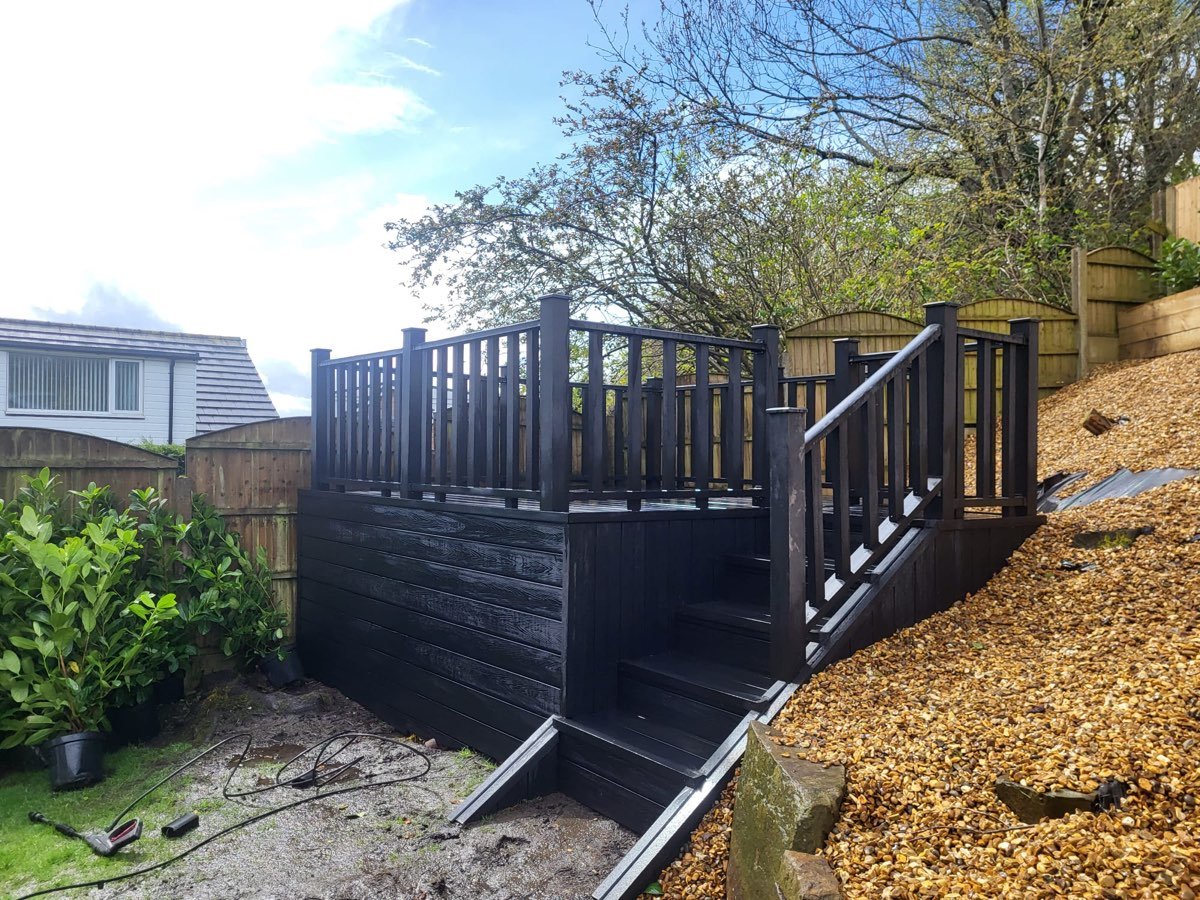 Raised black composite decking with steps and balustrade