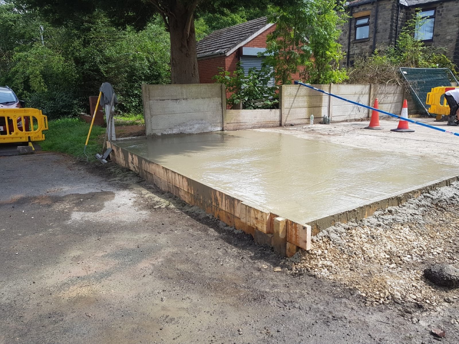 Concrete groundworks in progress with site barriers and cones