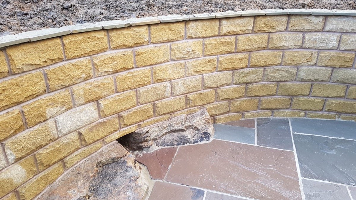 Curved natural stone retaining wall and patio
